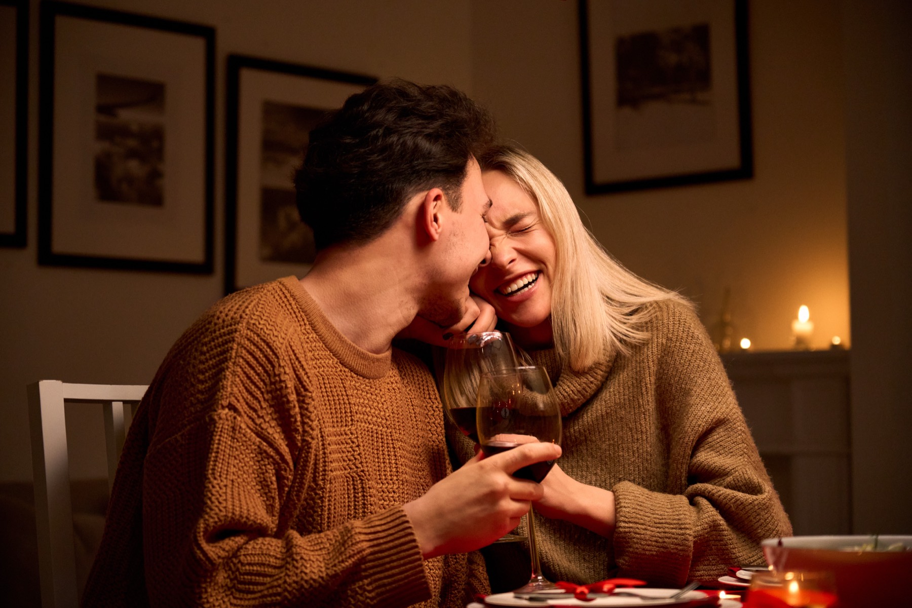 A couple sharing dinner at home by candlelight